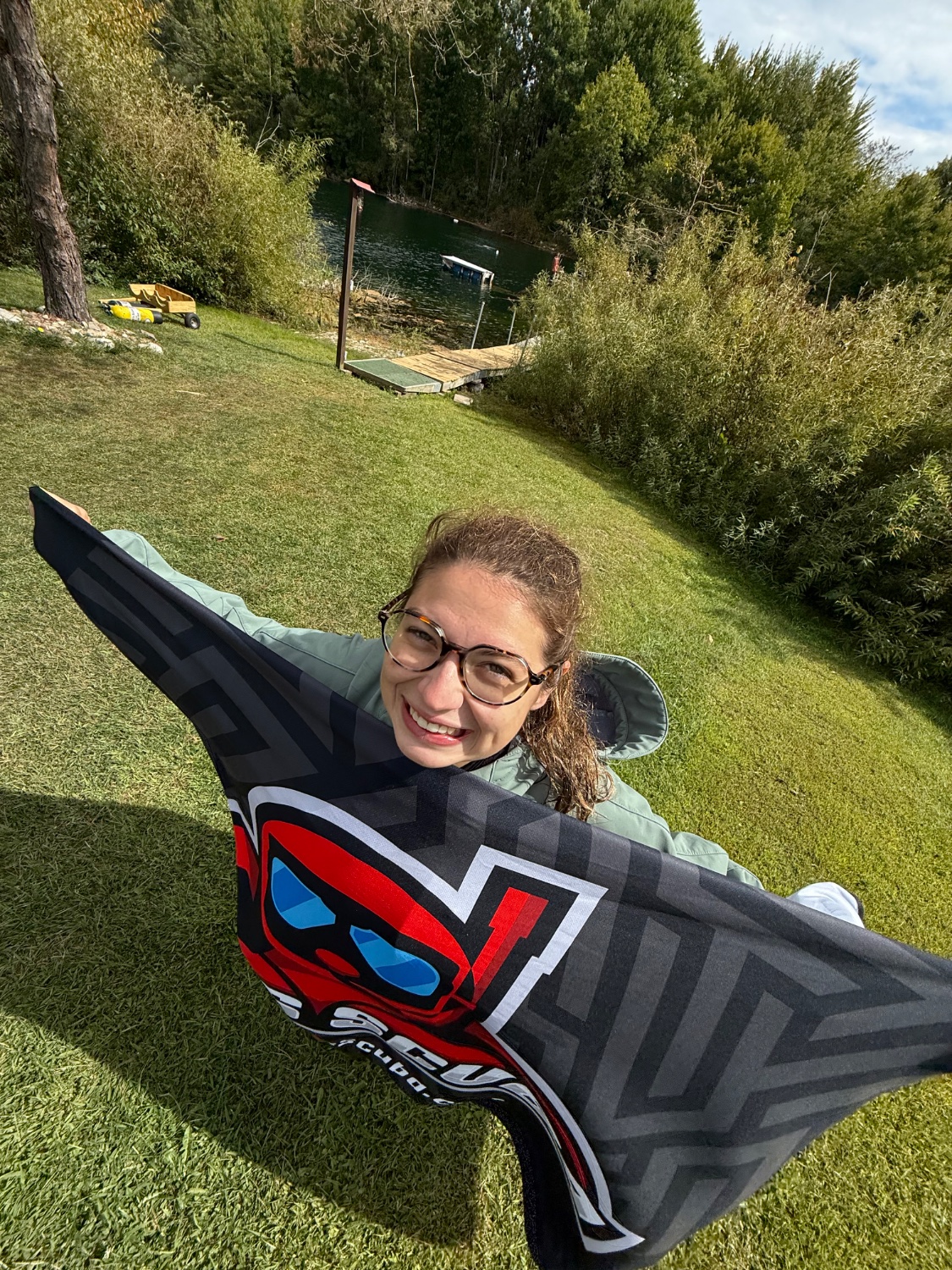 Bailey with a Mars Scuba flag by the lake