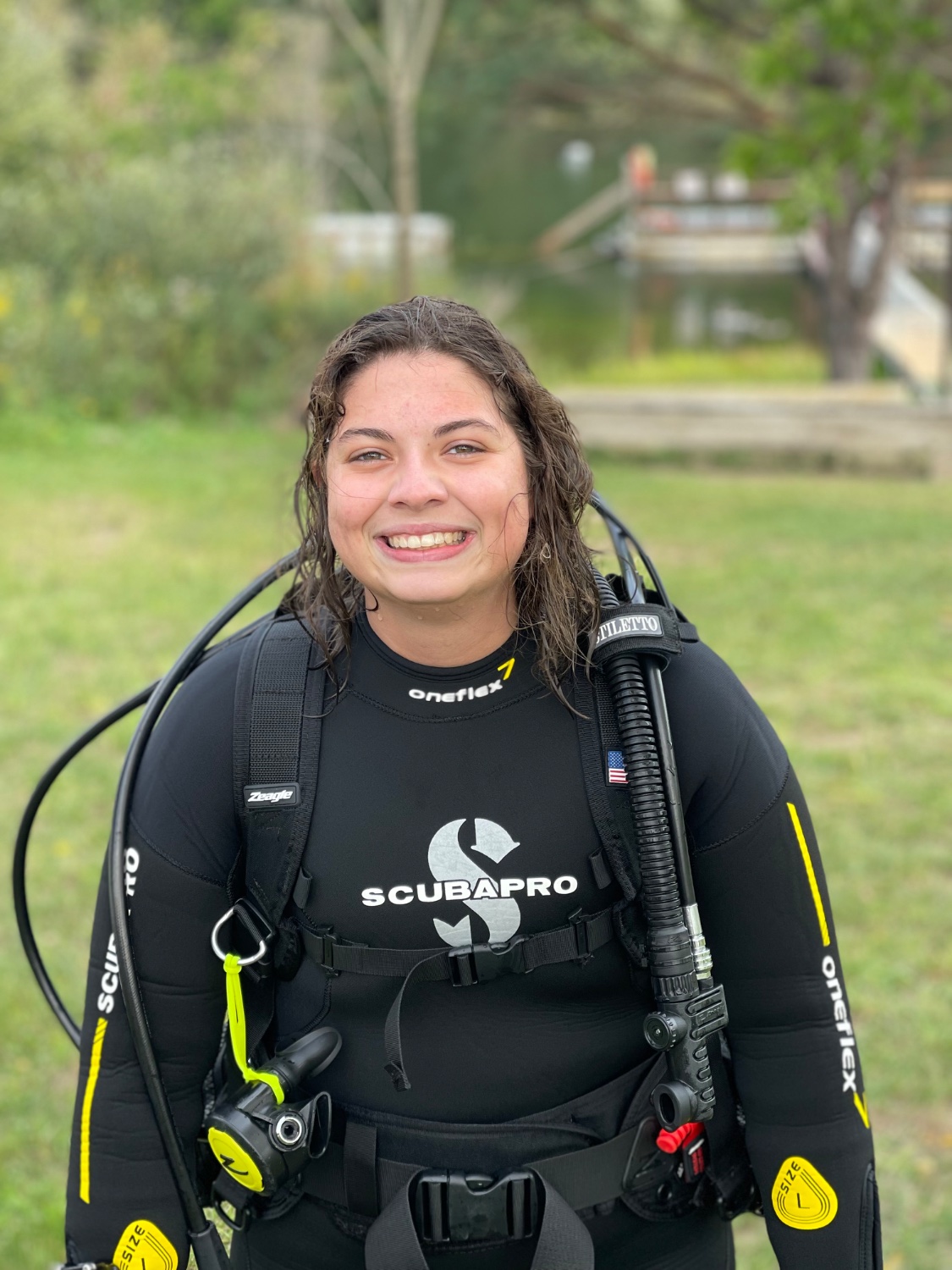 Bailey smiling in scuba gear by the water
